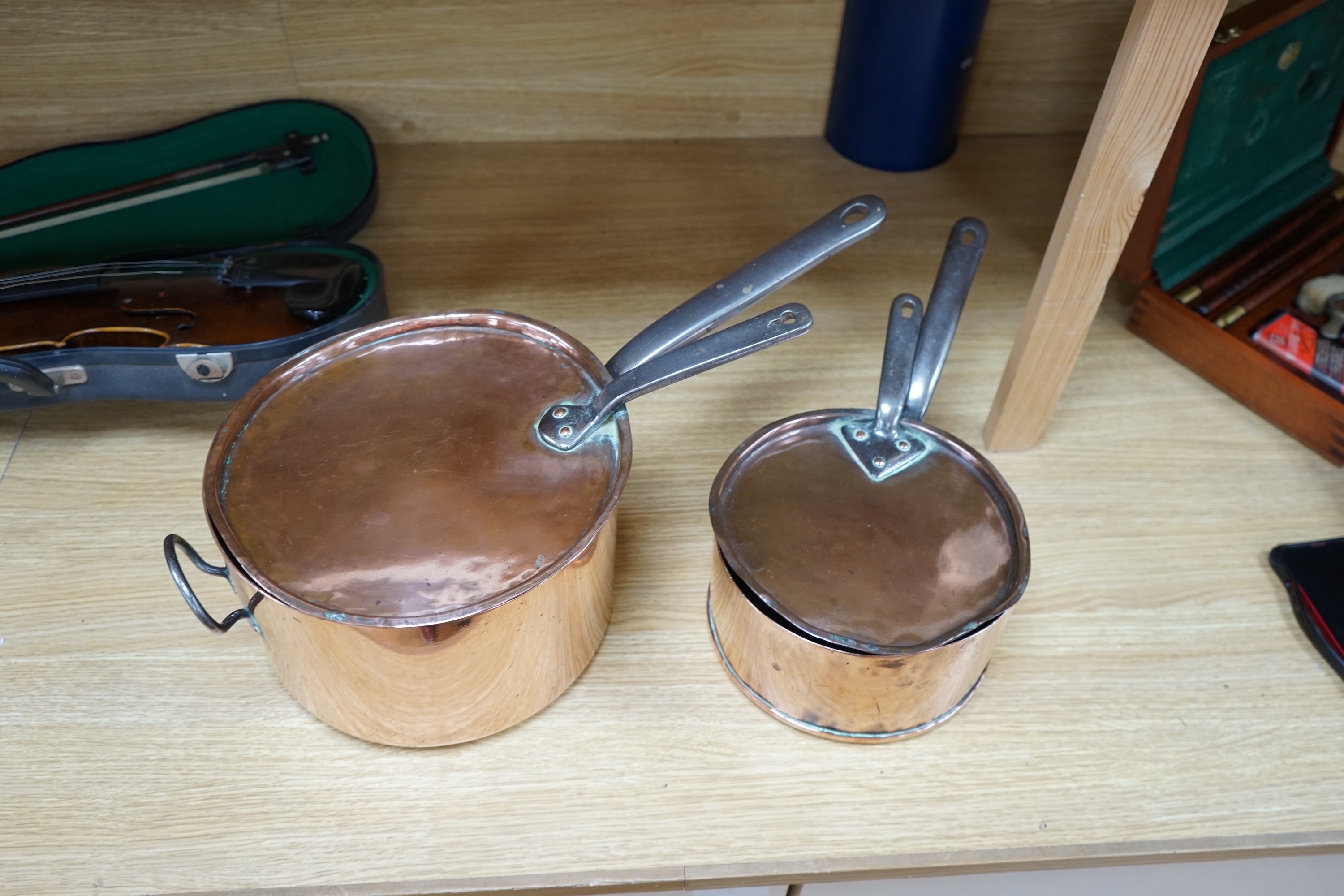 Two 19th century graduated copper and wrought iron saucepans and covers. Condition - fair to good